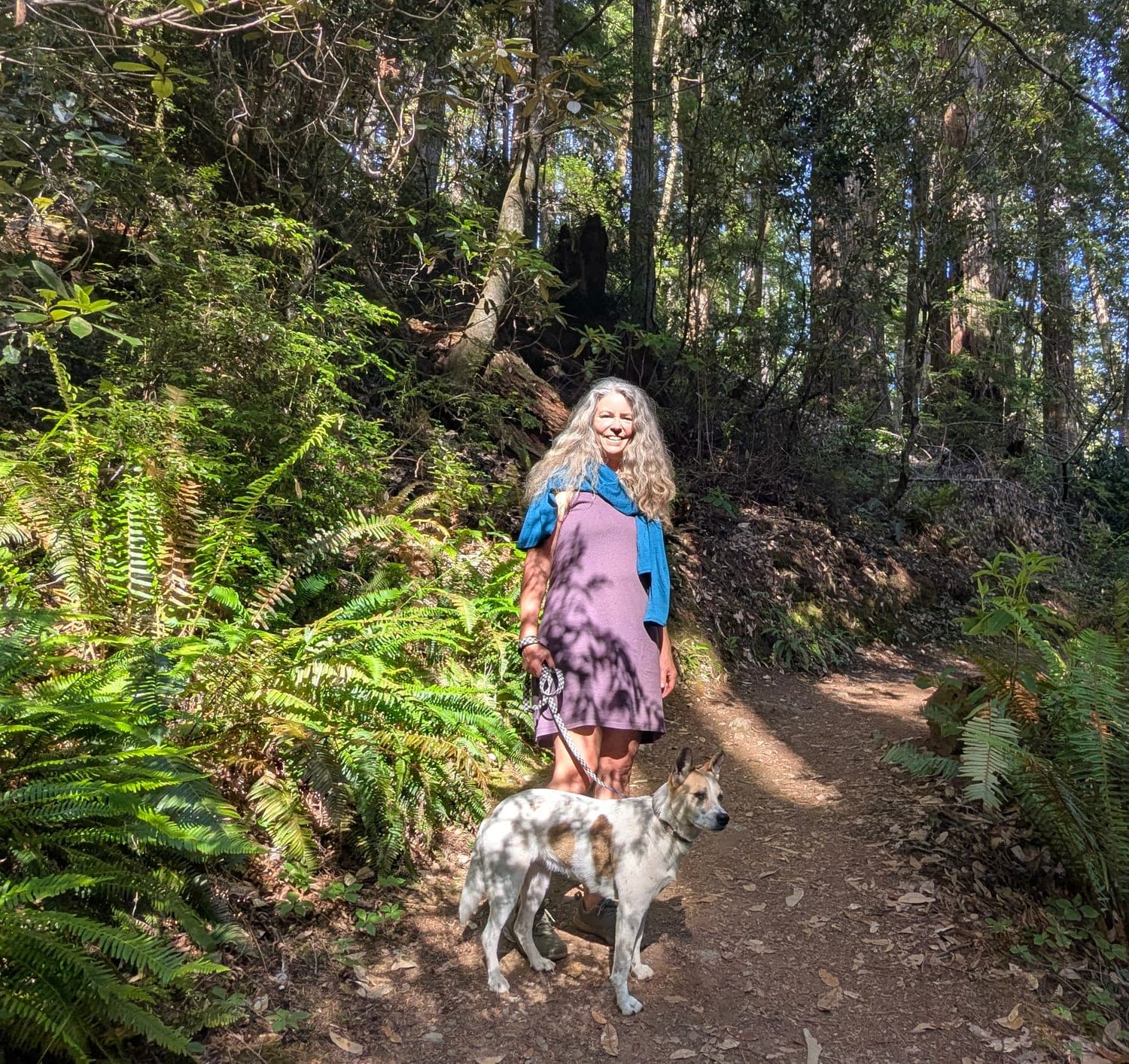 Rhianna and her dog Mercy on a fern-lined redwood trail